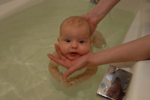 Купание в большой ванне новорожденного